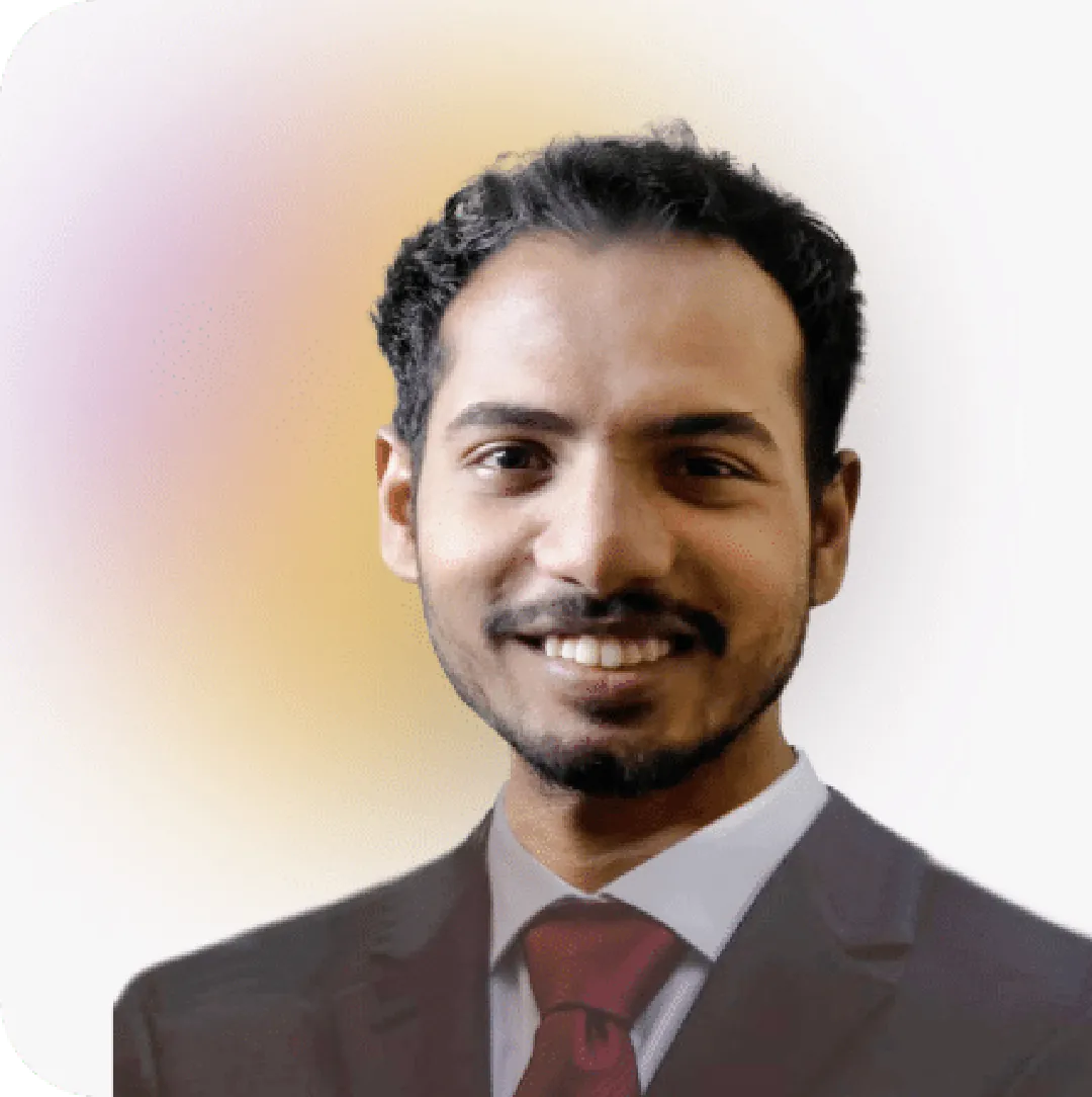 Tawfiq, Full-Stack developer at Media Pantheon, Inc., in a black suit and red tie, smiling warmly