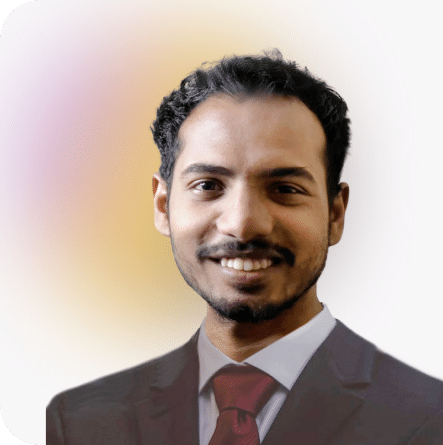Tawfiq, Full-Stack developer at Media Pantheon, Inc., in a black suit and red tie, smiling warmly