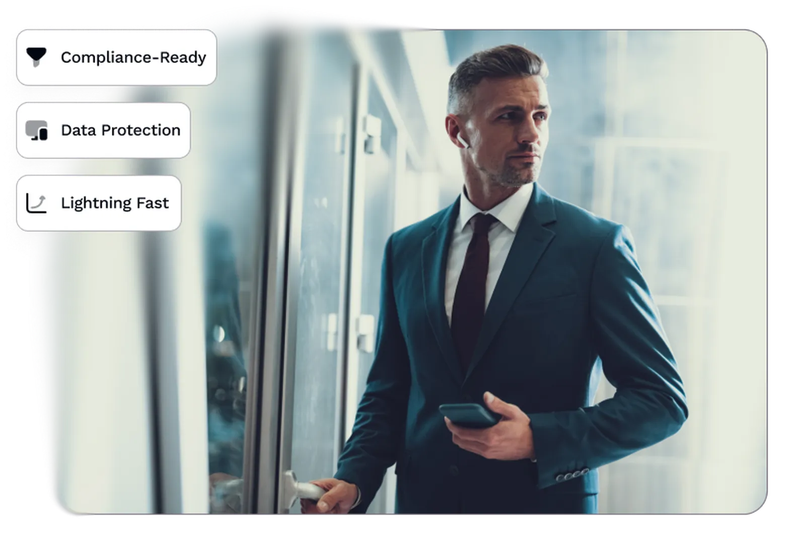 A man in deep blue formal dress-up holding a phone and opening a door, looking to his right.