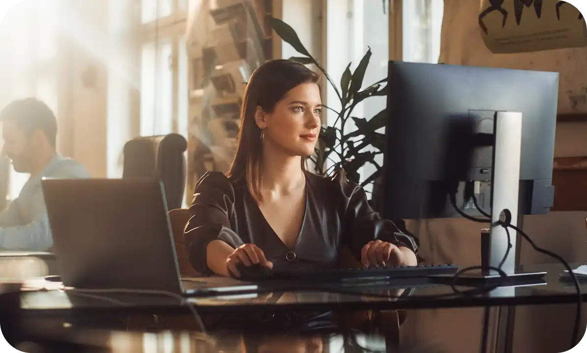 Brunette woman looking at a computer monitor.
